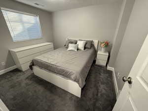 Carpeted bedroom featuring a textured ceiling