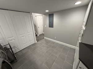 Washroom with electric panel and a textured ceiling