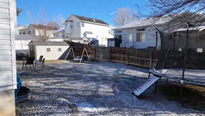 View of yard with a trampoline and a shed