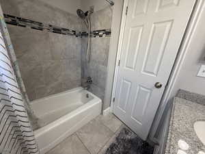 Bathroom featuring tile patterned flooring, vanity, and shower / bath combo with shower curtain