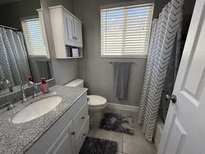 Bathroom featuring vanity, tile patterned floors, and toilet