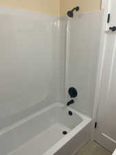 Bathroom with shower / tub combination and light wood-type flooring