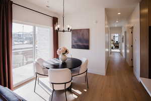 Dining area featuring light wood-type flooring and a notable chandelier