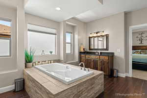 Bathroom with a relaxing tiled tub and vanity