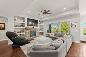 Living room with a fireplace, dark hardwood / wood-style floors, built in features, and a textured ceiling