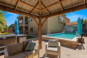 View of swimming pool featuring a gazebo, a hot tub, and a patio