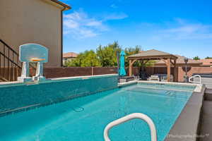 View of swimming pool with a gazebo and an outdoor hangout area