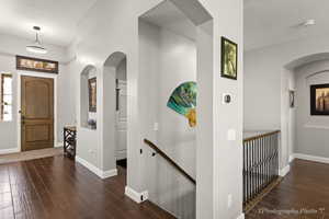 Foyer entrance with a textured ceiling and dark hardwood / wood-style flooring