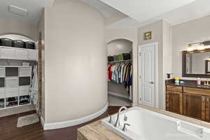 Bathroom featuring vanity, wood-type flooring, and a tub