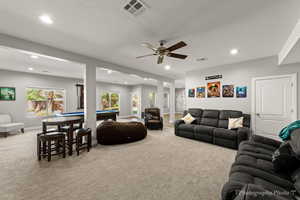 Carpeted living room with ceiling fan, billiards, and a textured ceiling