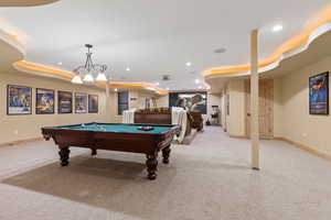 Rec room featuring light colored carpet, a raised ceiling, and billiards