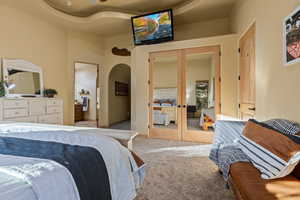 Carpeted bedroom with a closet and french doors