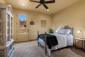 Bedroom featuring light carpet, access to exterior, and ceiling fan