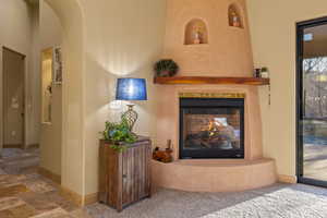 Details featuring carpet floors and a multi sided fireplace