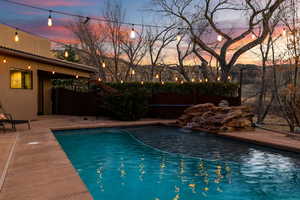 Pool at dusk with a patio area