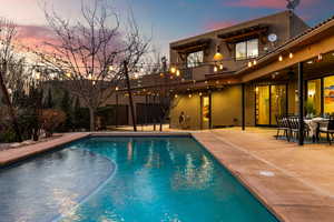 Pool at dusk with ceiling fan and a patio