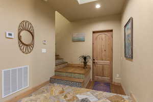 Entrance foyer with wood finished floors, baseboards, stairway, and recessed lighting