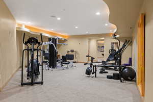 Workout room with light colored carpet