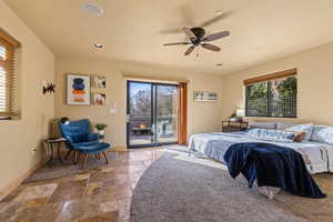 Bedroom featuring access to outside, stone tile flooring, multiple windows, baseboards, and recessed lighting