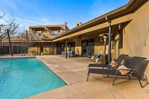 View of pool with ceiling fan and a patio