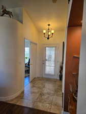 Entrance foyer featuring vaulted ceiling and a chandelier