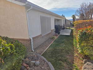 View of side of home featuring a yard and a patio