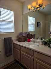 Bathroom with vanity, lofted ceiling, toilet, and a shower