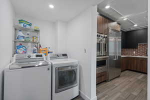 Laundry room featuring washer and clothes dryer and LVP flooring