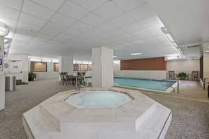 View of indoor swimming pool featuring an indoor in ground hot tub