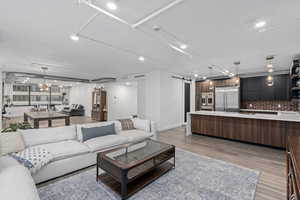 Living room with a barn door, waterfall island, raised ceiling height  and LVP flooring