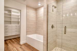 Bathroom featuring hardwood / wood-style flooring and separate shower and tub