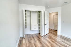 Unfurnished bedroom with a closet and light wood-type flooring