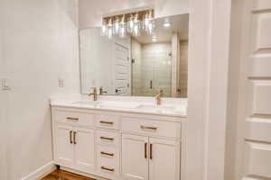 Bathroom with hardwood / wood-style flooring, vanity, and a shower with shower door