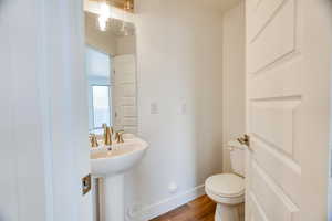 Bathroom featuring sink, toilet, and hardwood / wood-style floors