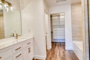 Bathroom featuring vanity, a tub to relax in, and hardwood / wood-style flooring