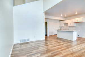 Kitchen featuring white cabinetry, sink, and light wood-type flooring