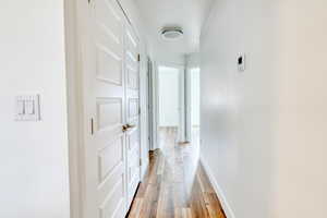 Corridor with light hardwood / wood-style flooring