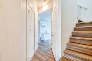 Staircase featuring sink and hardwood / wood-style floors