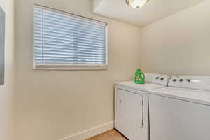 Clothes washing area featuring light tile patterned flooring and washing machine and clothes dryer