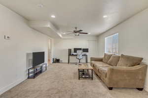 Carpeted living room featuring ceiling fan