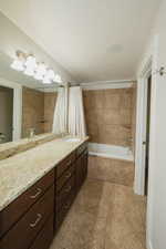 Bathroom with vanity, tile patterned floors, and shower / bath combo with shower curtain