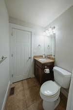 Bathroom featuring vanity, toilet, and tile patterned flooring