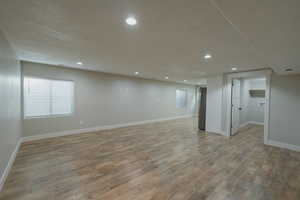 Basement featuring light hardwood / wood-style flooring and a textured ceiling