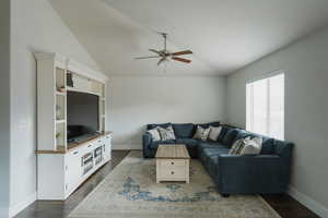 Living room with lofted ceiling, dark wood-type flooring, and ceiling fan