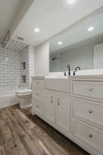 Bathroom with hardwood / wood-style flooring, vanity, and toilet