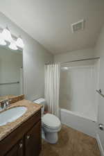 Full bathroom with tile patterned flooring, vanity, shower / bath combo with shower curtain, and toilet