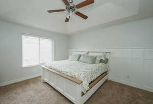 Carpeted bedroom featuring ceiling fan