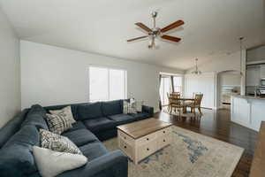 Living room with vaulted ceiling, dark wood-type flooring, sink, and ceiling fan