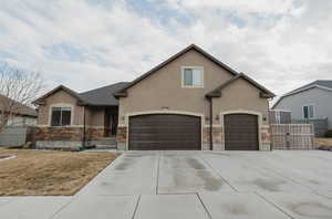 View of front of property featuring a garage and a front lawn