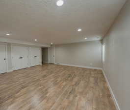 Basement with a textured ceiling and light wood-type flooring